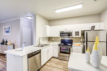 A modern kitchen with white appliances and cabinets.